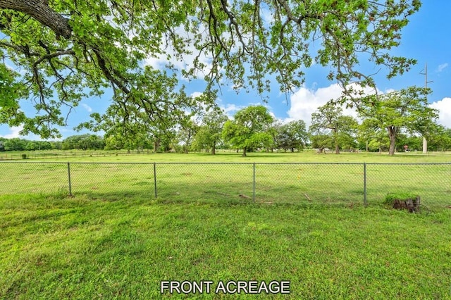 view of yard featuring fence and a rural view