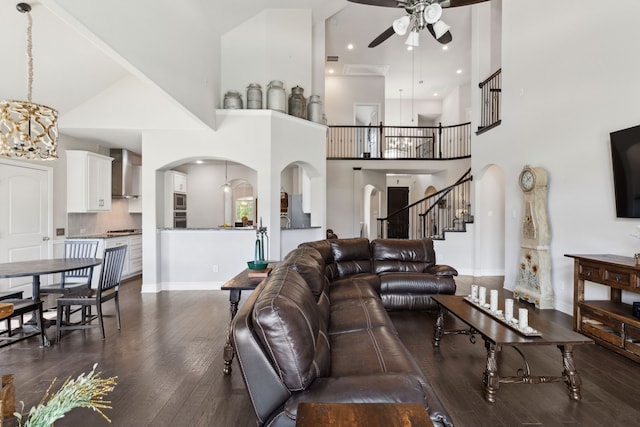 619 Southwestern Dr, Rockwall, TX 75087 - living room featuring arched walkways, ceiling fan, dark wood finished floors, a towering ceiling, and stairway