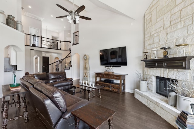 619 Southwestern Dr, Rockwall, TX 75087 - living room with ceiling fan, arched walkways, a fireplace, a towering ceiling, and wood finished floors