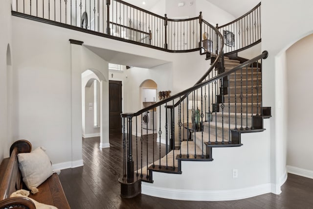 619 Southwestern Dr, Rockwall, TX 75087 - staircase featuring arched walkways, a high ceiling, and hardwood / wood-style flooring
