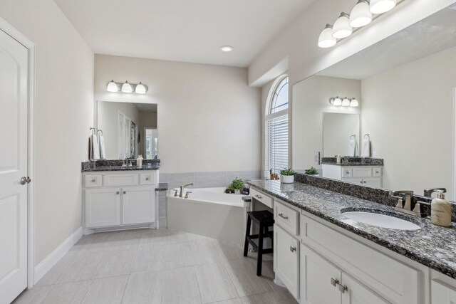 619 Southwestern Dr, Rockwall, TX 75087 - full bathroom featuring two vanities, a garden tub, and tile patterned floors