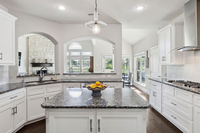 619 Southwestern Dr, Rockwall, TX 75087 - kitchen with wall chimney range hood, stainless steel gas stovetop, vaulted ceiling, healthy amount of natural light, and backsplash
