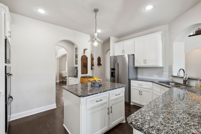 619 Southwestern Dr, Rockwall, TX 75087 - kitchen featuring arched walkways, appliances with stainless steel finishes, dark wood finished floors, backsplash, and recessed lighting