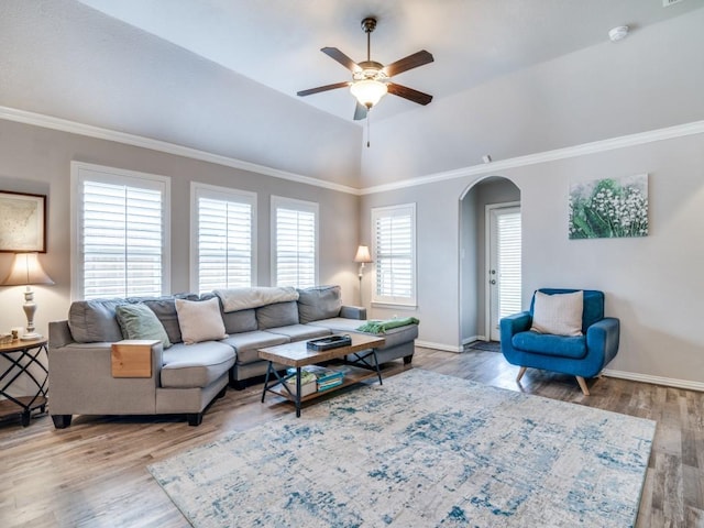 living area with baseboards, a ceiling fan, arched walkways, and wood finished floors