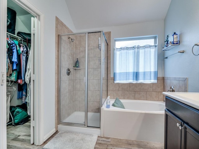 175 Balfour Dr, Fate, TX 75189 - bathroom featuring wood finished floors, a bath, a stall shower, a walk in closet, and vanity