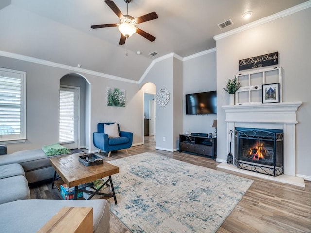 175 Balfour Dr, Fate, TX 75189 - living area featuring arched walkways, ceiling fan, wood finished floors, a lit fireplace, and lofted ceiling