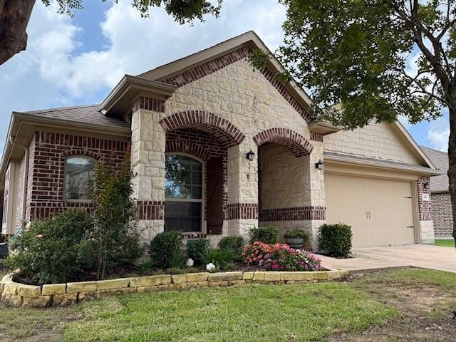 175 Balfour Dr, Fate, TX 75189 - view of front of house with stone siding, a garage, driveway, and brick siding