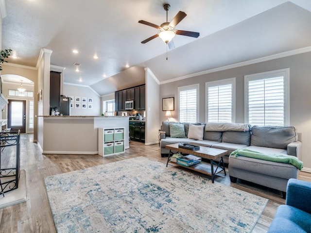 175 Balfour Dr, Fate, TX 75189 - living room with crown molding, ceiling fan, lofted ceiling, light wood-style flooring, and arched walkways