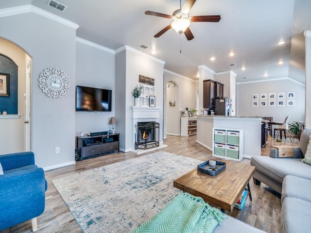 175 Balfour Dr, Fate, TX 75189 - living area featuring arched walkways, a ceiling fan, light wood finished floors, crown molding, and recessed lighting