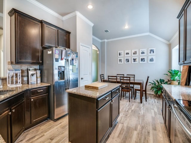 175 Balfour Dr, Fate, TX 75189 - kitchen with appliances with stainless steel finishes, light wood-style floors, light stone counters, arched walkways, and dark brown cabinets