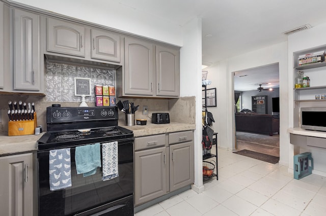 kitchen with visible vents, ceiling fan, gray cabinetry, decorative backsplash, and electric range