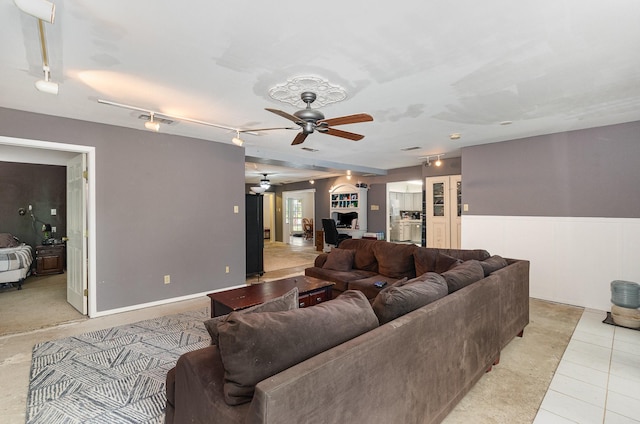 living area featuring rail lighting, light tile patterned floors, wainscoting, visible vents, and ceiling fan