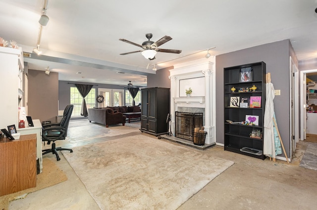 office space with a fireplace, concrete floors, and a ceiling fan