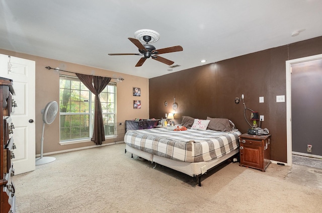 bedroom featuring light carpet, visible vents, baseboards, and a ceiling fan