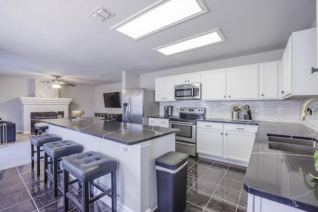 3144 Longbow Dr, Grand Prairie, TX 75052 - kitchen featuring a breakfast bar area, visible vents, dark countertops, a sink, and stainless steel appliances