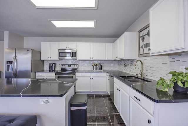 3144 Longbow Dr, Grand Prairie, TX 75052 - kitchen with dark countertops, tasteful backsplash, a sink, stainless steel appliances, and white cabinetry