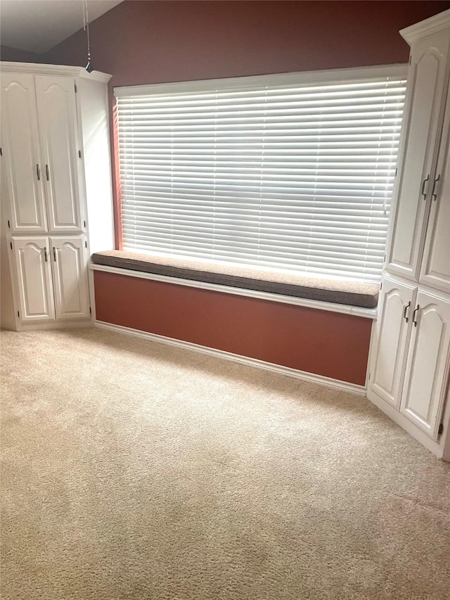 unfurnished bedroom featuring carpet floors, baseboards, and vaulted ceiling