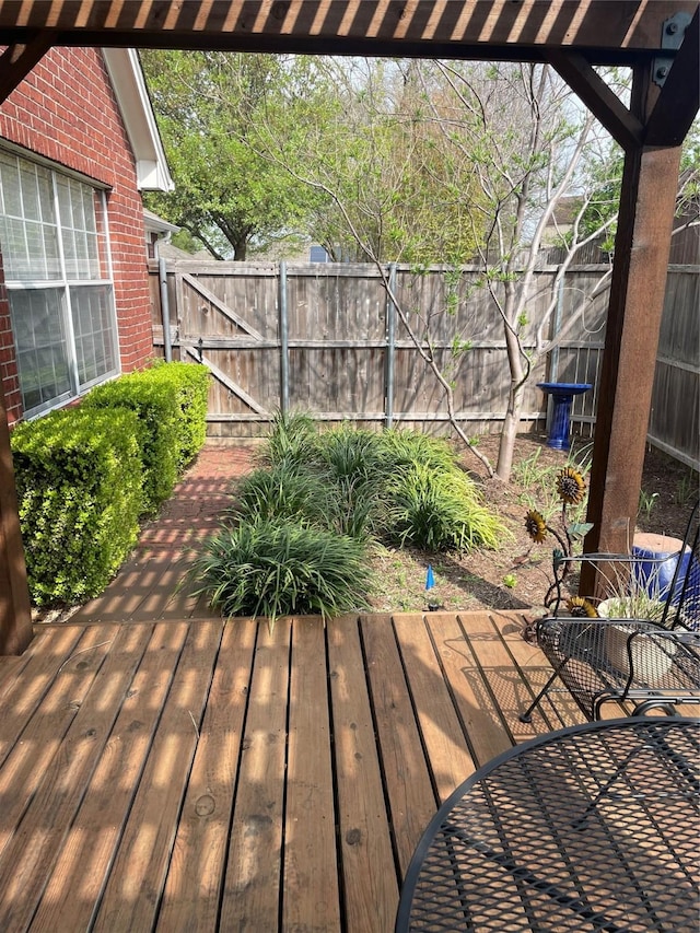 wooden terrace featuring fence and a gate
