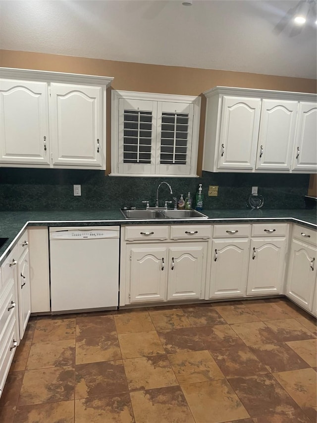 kitchen with backsplash, dark countertops, dishwasher, a sink, and white cabinets