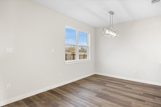 525 Galt Dr, Stephenville, TX 76401 - unfurnished room featuring dark wood-type flooring, an inviting chandelier, baseboards, and visible vents