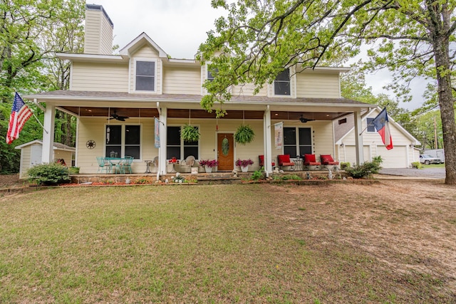 view of front facade featuring ceiling fan, an outdoor structure, a front lawn, and covered porch