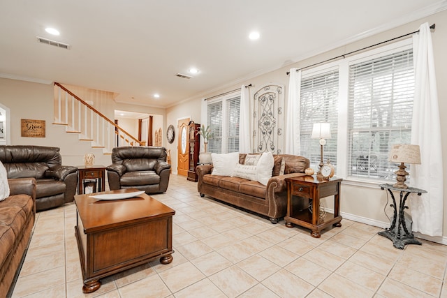 living area featuring light tile patterned floors, ornamental molding, visible vents, and stairway
