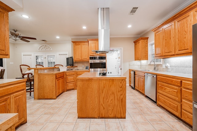 kitchen with visible vents, a sink, a ceiling fan, a peninsula, and stainless steel appliances