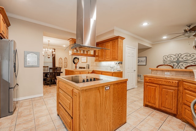 kitchen with light tile patterned floors, stainless steel fridge, island exhaust hood, black electric stovetop, and ceiling fan with notable chandelier
