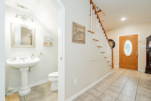 tiled entrance foyer with crown molding, visible vents, baseboards, and stairway