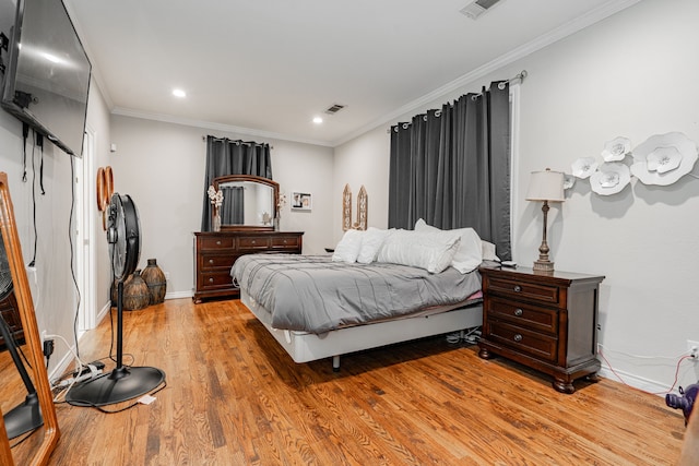 bedroom featuring visible vents, ornamental molding, baseboards, and light wood-style floors