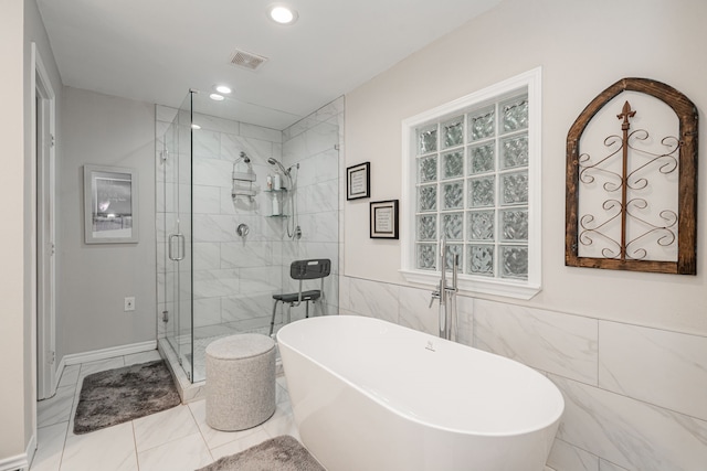 full bath featuring visible vents, a freestanding bath, recessed lighting, marble finish floor, and a stall shower