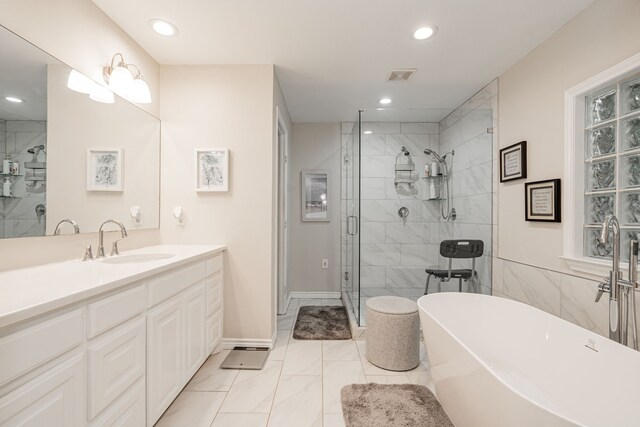 full bathroom featuring vanity, a stall shower, a soaking tub, visible vents, and marble finish floor