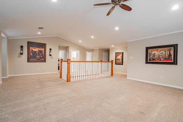 spare room featuring ceiling fan, ornamental molding, vaulted ceiling, visible vents, and baseboards