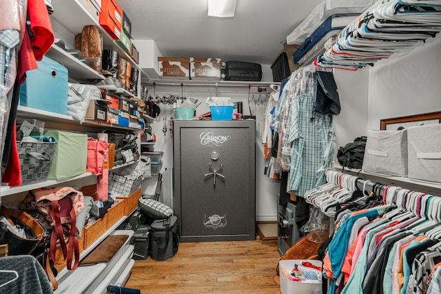 walk in closet with wood finished floors