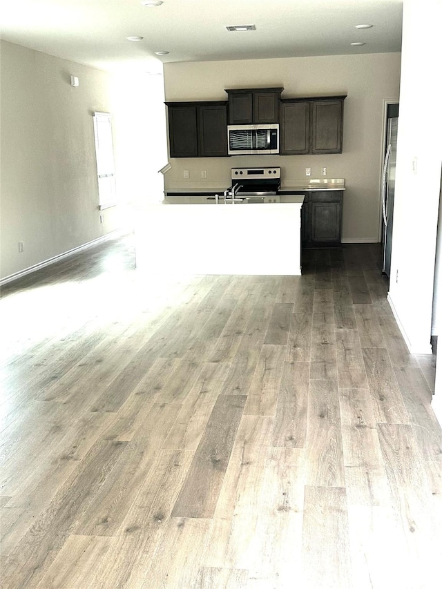 kitchen featuring open floor plan, light wood-type flooring, appliances with stainless steel finishes, and visible vents