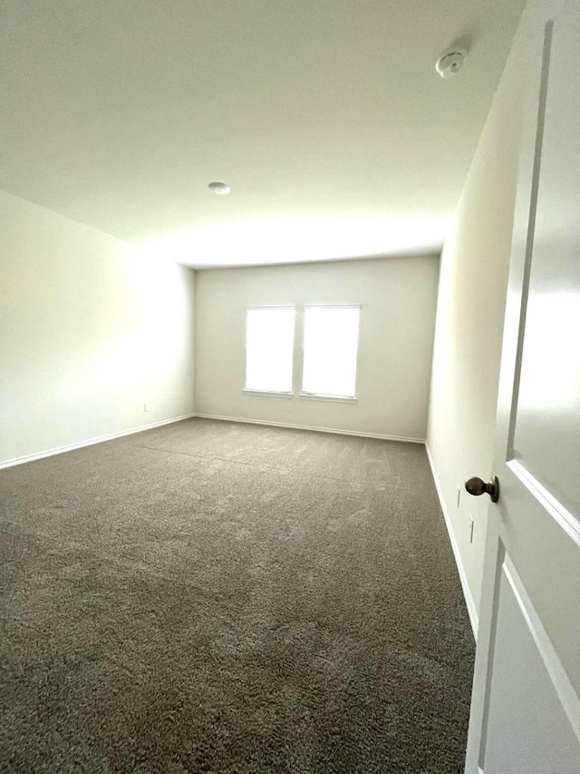 carpeted empty room with baseboards