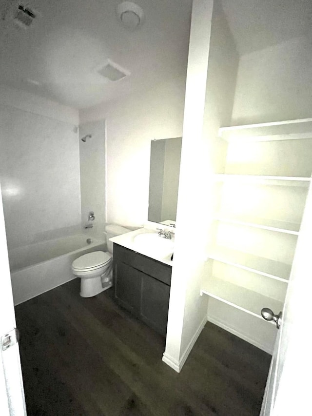 bathroom featuring vanity, visible vents, toilet, wood finished floors, and shower / bathing tub combination