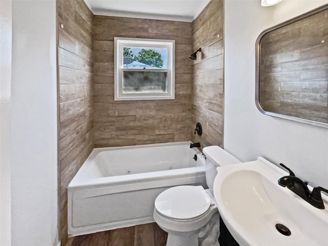 1209 Sylvan Dr, Garland, TX 75040 - bathroom featuring a sink, toilet, a combined bath / shower with jetted tub, and wood finished floors