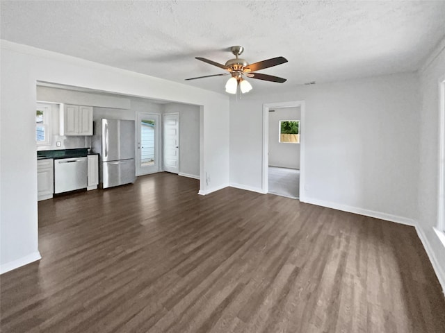 1209 Sylvan Dr, Garland, TX 75040 - unfurnished living room featuring dark wood-style floors, a ceiling fan, baseboards, and a textured ceiling