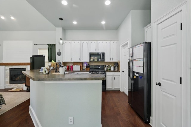 1236 Spanish Moss Dr, Savannah, TX 76227 - kitchen featuring stainless steel appliances, dark countertops, dark wood finished floors, white cabinetry, and recessed lighting
