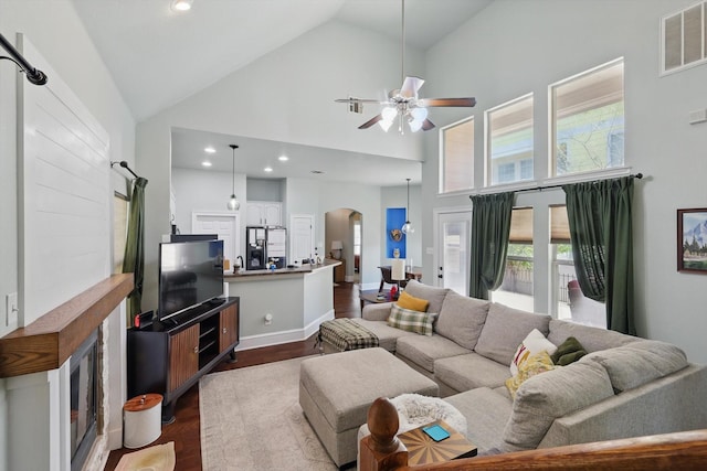 1236 Spanish Moss Dr, Savannah, TX 76227 - living area featuring arched walkways, dark wood-style flooring, high vaulted ceiling, ceiling fan, and plenty of natural light