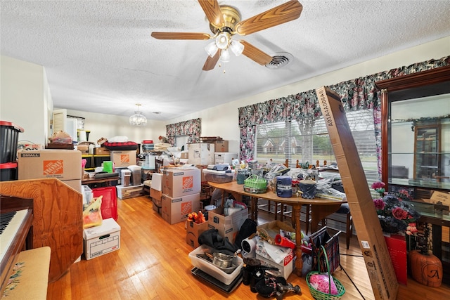 2107 Elizabeth Dr, Brownwood, TX 76801 - interior space featuring wood-type flooring, visible vents, ceiling fan with notable chandelier, and a textured ceiling