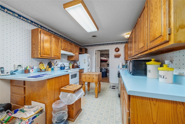 2107 Elizabeth Dr, Brownwood, TX 76801 - kitchen with wallpapered walls, white appliances, light countertops, brown cabinets, and light floors