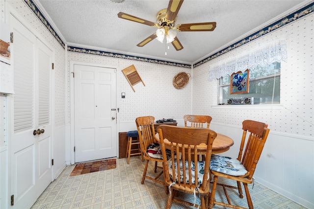 2107 Elizabeth Dr, Brownwood, TX 76801 - dining room featuring wallpapered walls, a textured ceiling, a ceiling fan, wainscoting, and light floors