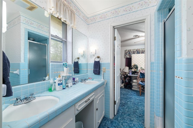 2107 Elizabeth Dr, Brownwood, TX 76801 - full bath featuring double vanity, wallpapered walls, a stall shower, a wainscoted wall, and a sink