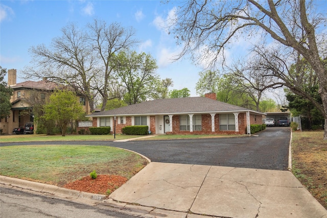 2107 Elizabeth Dr, Brownwood, TX 76801 - view of front of home featuring a chimney, curved driveway, a front lawn, and brick siding
