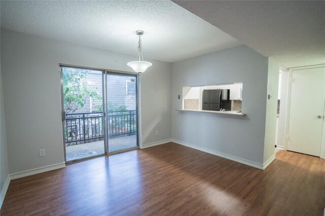 4020 Holland Ave Unit 202, Dallas, TX 75219 - unfurnished living room with a wood stove, wood finished floors, a textured ceiling, and baseboards