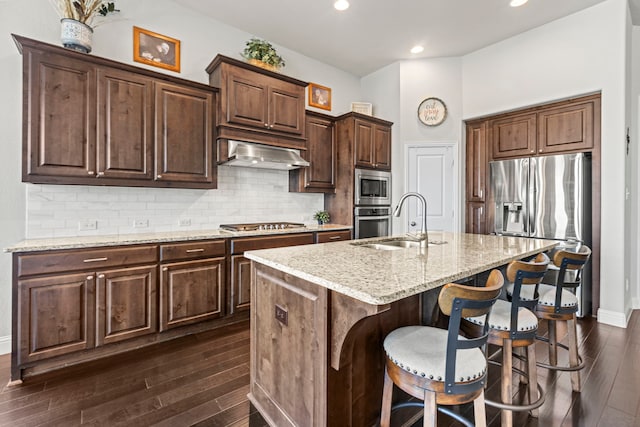 1036 Wedgewood Dr, Forney, TX 75126 - kitchen with appliances with stainless steel finishes, dark wood finished floors, a breakfast bar area, exhaust hood, and light stone counters