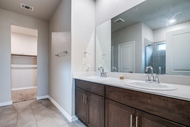 5219 Amistad Ave, Royse City, TX 75189 - bathroom featuring a shower stall, double vanity, baseboards, a walk in closet, and tile patterned floors