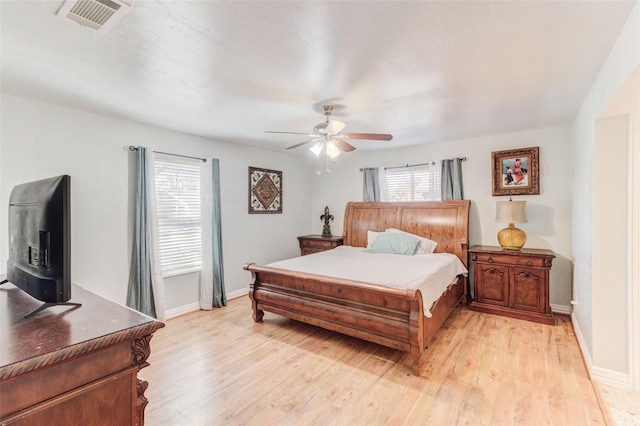 4842 Stallcup Dr, Mesquite, TX 75150 - bedroom featuring light wood-style flooring, baseboards, ceiling fan, visible vents, and a wood stove